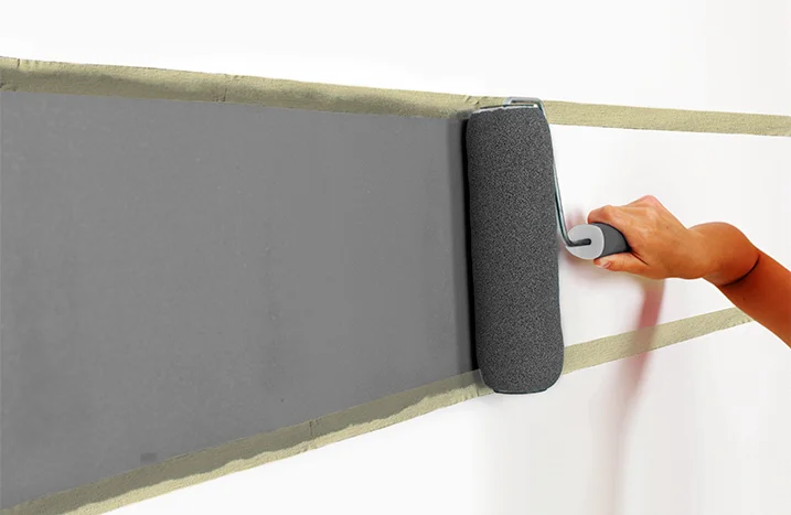 Hand streicht Wand grau